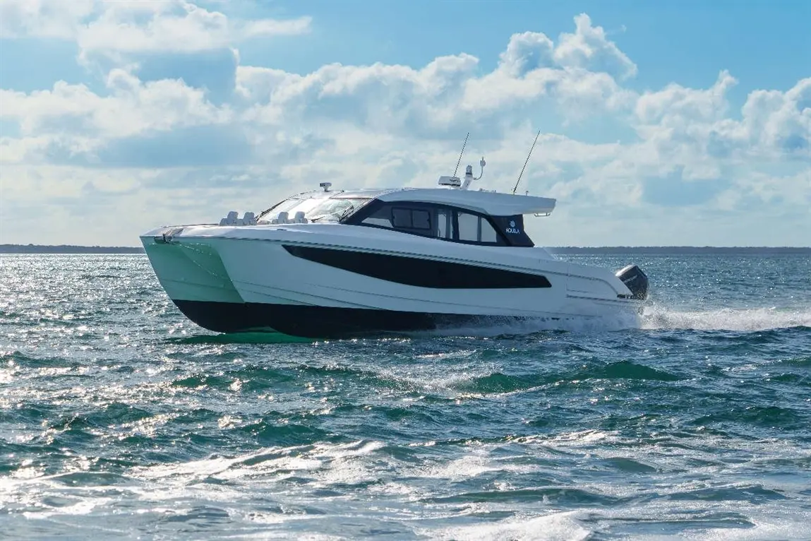 A sleek white powerboat cruising through sparkling blue water under a partly cloudy sky, showcasing luxury and adventure.